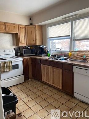 Kalamazoo house for rent - A kitchen with wooden cabinets and a white dishwasher.