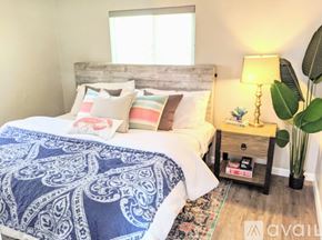 San Diego apartment for rent - A bedroom with a bed covered in a blue and white patterned comforter.