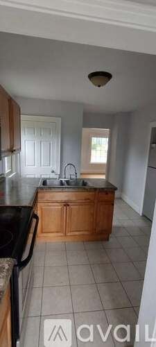Kalamazoo house for rent - A kitchen with wooden cabinets and a black countertop.