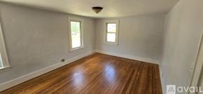 Kalamazoo house for rent - A room with wooden floors and two windows.