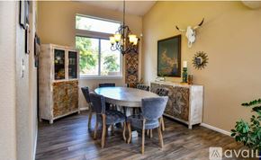Arvada house for rent - A dining room with a table set for six and a chandelier hanging from the ceiling.