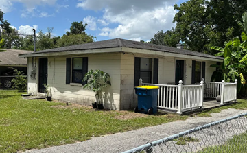 Jacksonville house for rent - A small house with a white fence and a blue trash can.