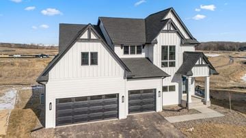 Maple Grove house for rent - A large white house with a black roof and a garage door.