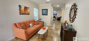 Clearwater house for rent - A living room with a couch, a coffee table, and a painting on the wall.
