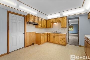 Franklin house for rent - A kitchen with wooden cabinets and a white door.