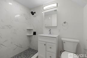 Boston apartment for rent - A bathroom with marble walls and a white toilet.