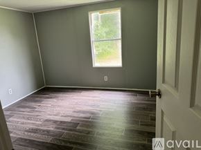 Zebulon house for rent - A room with a window and a wooden floor.