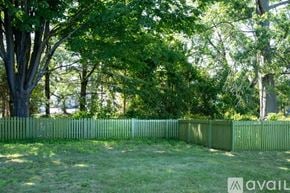 Danvers house for rent - A green fenced area with trees in the background.
