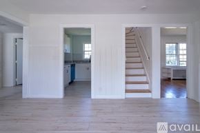 Danvers house for rent - A spacious living area with a staircase leading to the upper floor.