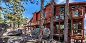 Stateline condo for rent - A wooden cabin with a balcony surrounded by trees.