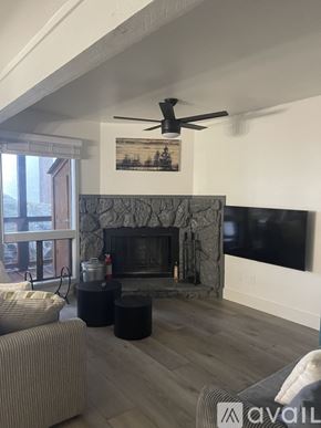 Stateline condo for rent - A living room with a stone fireplace and a flat screen TV mounted above it.