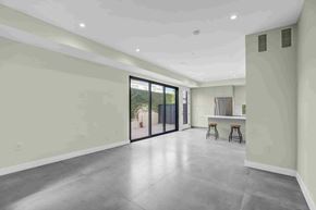 Los Angeles house for rent - A spacious room with a bar area and sliding glass doors.