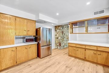 Northridge house for rent - A kitchen with wooden cabinets and a refrigerator.