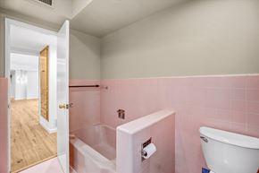 Northridge house for rent - A bathroom with a pink wall and a white tub.