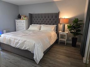 Inglewood house for rent - A bedroom with a large bed and a grey headboard.