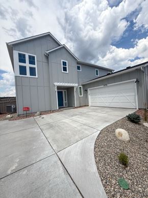 Colorado Springs house for rent - A grey house with a white garage door and a red sign on the fence.