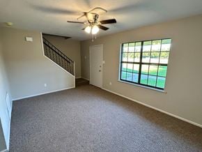 Bay City apartment for rent - A room with a carpeted floor, a ceiling fan, and a window with a view of a lawn.