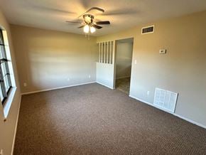 Bay City apartment for rent - A room with a ceiling fan and carpeted floor.