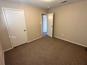 Bay City apartment for rent - A carpeted room with two doors, one of which is open.