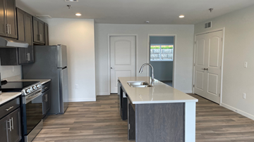 Mandan townhouse for rent - A kitchen with a white counter top and black cabinets.
