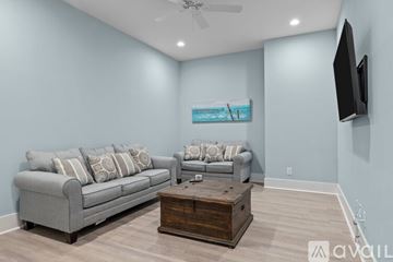Emerald Isle house for rent - A living room with a grey couch and a wooden coffee table.