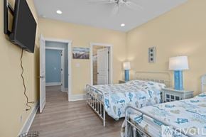 Emerald Isle house for rent - A bedroom with two beds and a television mounted on the wall.