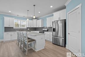 Emerald Isle house for rent - A kitchen with a large island and a stainless steel refrigerator.