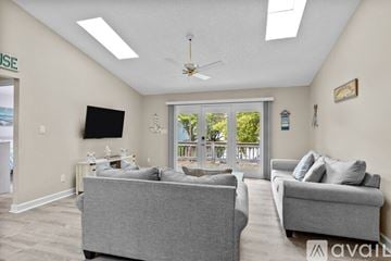 Emerald Isle house for rent - A living room with two grey couches and a flat screen TV mounted on the wall.