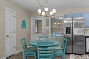 Emerald Isle house for rent - A kitchen with a table and chairs and a fridge.