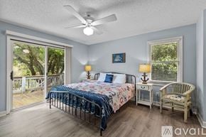 Emerald Isle house for rent - A bedroom with a bed, chair, and sliding glass doors.