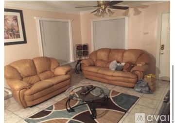 Delray Beach house for rent - A living room with two tan couches and a rug.