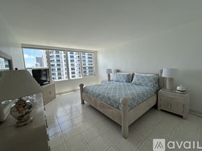 Hollywood apartment for rent - A bedroom with a large bed and a window overlooking a cityscape.