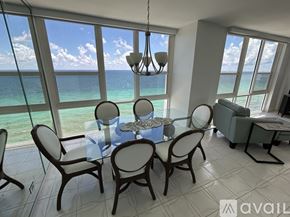 Hollywood apartment for rent - A dining room with a table set for four and a view of the ocean.