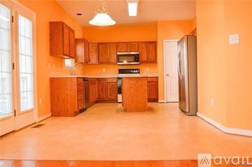 Richmond house for rent - A kitchen with wooden cabinets and a refrigerator.