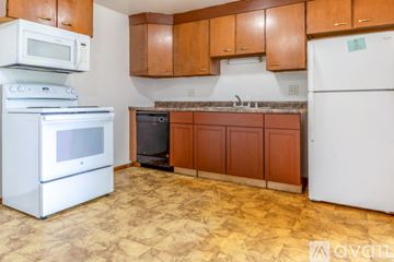 Madison apartment for rent - A kitchen with brown cabinets and a white fridge.