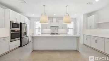 Orlando townhouse for rent - A modern kitchen with white cabinets and appliances.