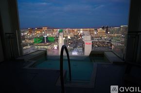 Las Vegas apartment for rent - A view of a cityscape from a window overlooking a pool at dusk.