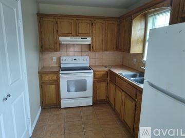 Edinburg apartment for rent - A kitchen with wooden cabinets and a white stove top oven.