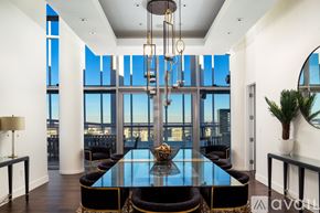 Las Vegas apartment for rent - A modern dining room with a glass table and black chairs.