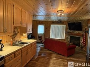 Long Prairie house for rent - A kitchen with wooden cabinets and a red couch.