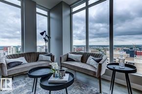 Edmonton townhouse for rent - A modern kitchen with a dining table and chairs is visible through a glass wall.