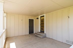 Parker house for rent - A room with a black door and a window with yellow bars.