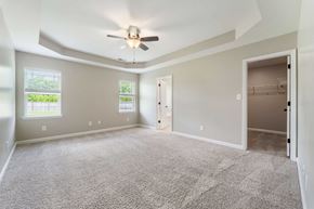 Hubert house for rent - A spacious room with a ceiling fan and carpeted floor.