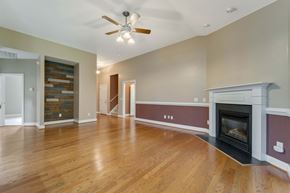 Jacksonville house for rent - A living room with a fireplace and a ceiling fan.