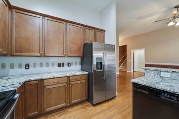 Jacksonville house for rent - A kitchen with wooden cabinets and a marble countertop.