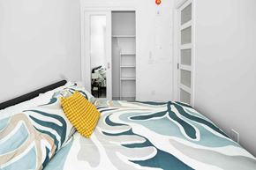 Winnipeg apartment for rent - A bed with a yellow pillow and a blue and white comforter.