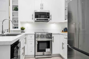 Winnipeg apartment for rent - A modern kitchen with white cabinets and stainless steel appliances.