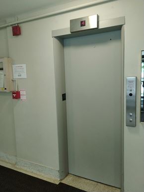 Belleville apartment for rent - A metal door with a silver handle and a red fire alarm on the wall.