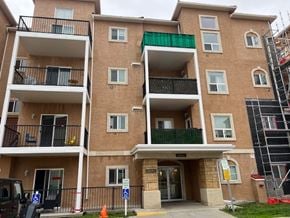 Edmonton house for rent - A multi-story apartment building with a green awning and a sign that reads "Parking.".