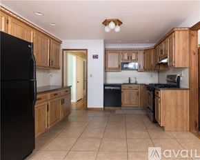 Fairfield house for rent - A kitchen with wooden cabinets and black appliances.